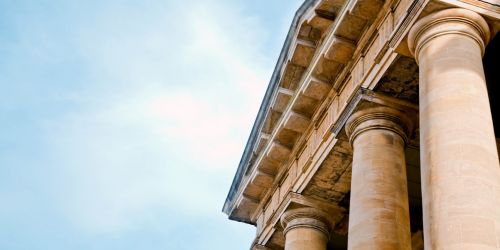 Geldwäschebeauftragter schaut auf ein altes römisches Säulengebäude